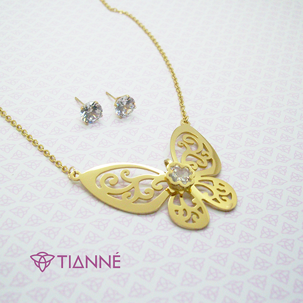 Juego en acero dorado con una placa en forma de mariposa y zirconia,aretes y collar.