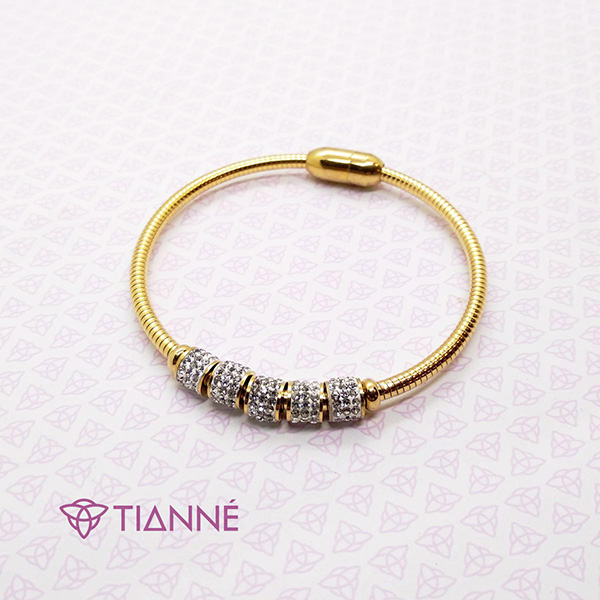 Brazalete acero dorado con imán para cerrar y placa con piedras.