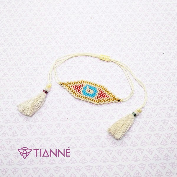 Pulsera de hilo con plaquita de tejido miyuki en forma de ojo.